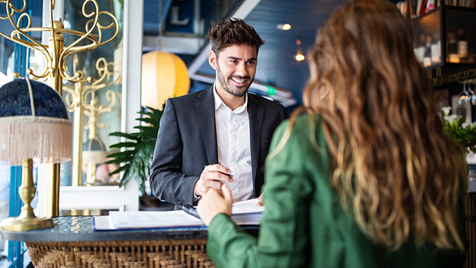 Hotel manager taking a booking at reception