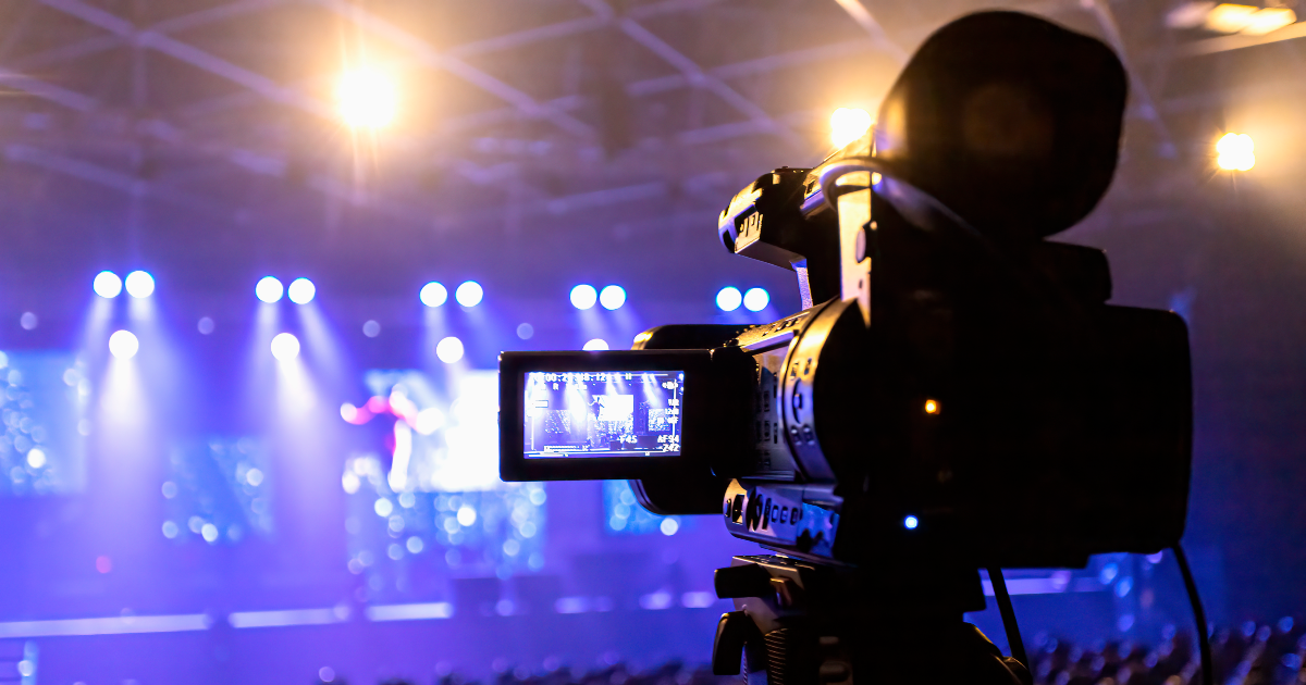 A video camera filming a stage. Event technology in action